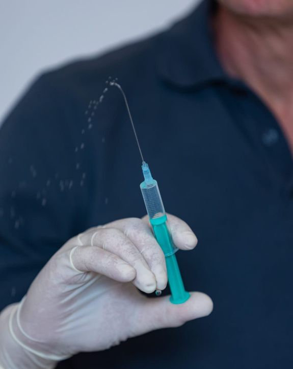 Nahansicht von Dr. Hasch Hand mit Spritze