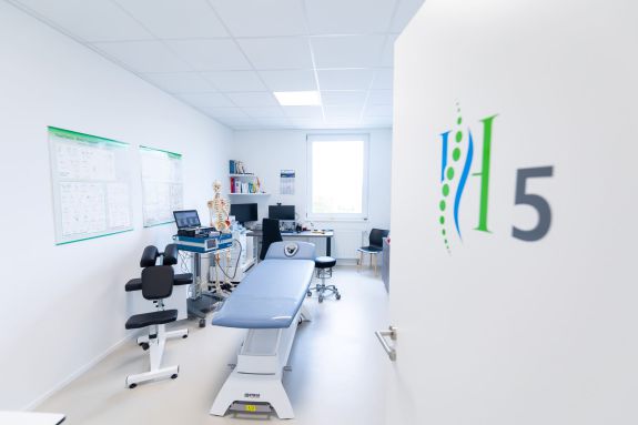 Einblick in Behandlungszimmer 5 mit Patientenliege und Geräten